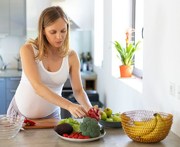 pregnant woman preparing healthy meal