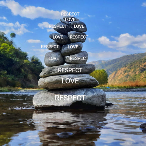 Several rocks on the water with the words love and respect written on them