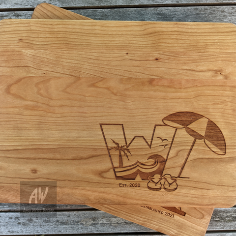 Cherry wood cutting board with the letter W, flip-flops, and a beach umbrella.