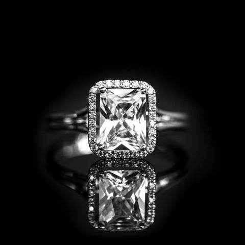 halo engagement ring set with an emerald cut centre diamond