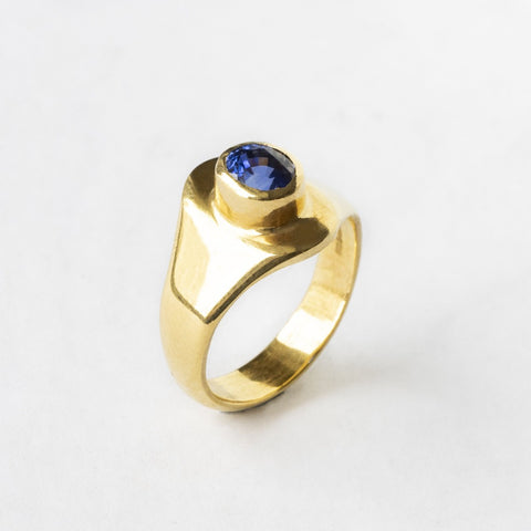 ring set with a blue sapphire in a bezel setting