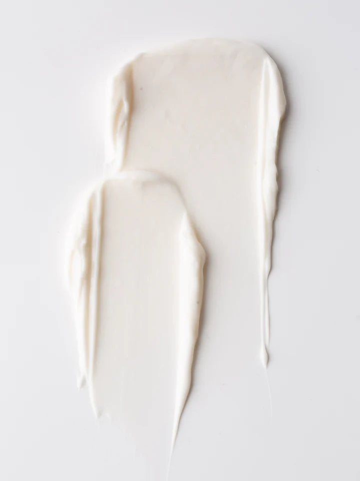 Two smears of white cream on a white surface.