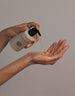 Woman pouring Fount Oil Cleanser on her hand.