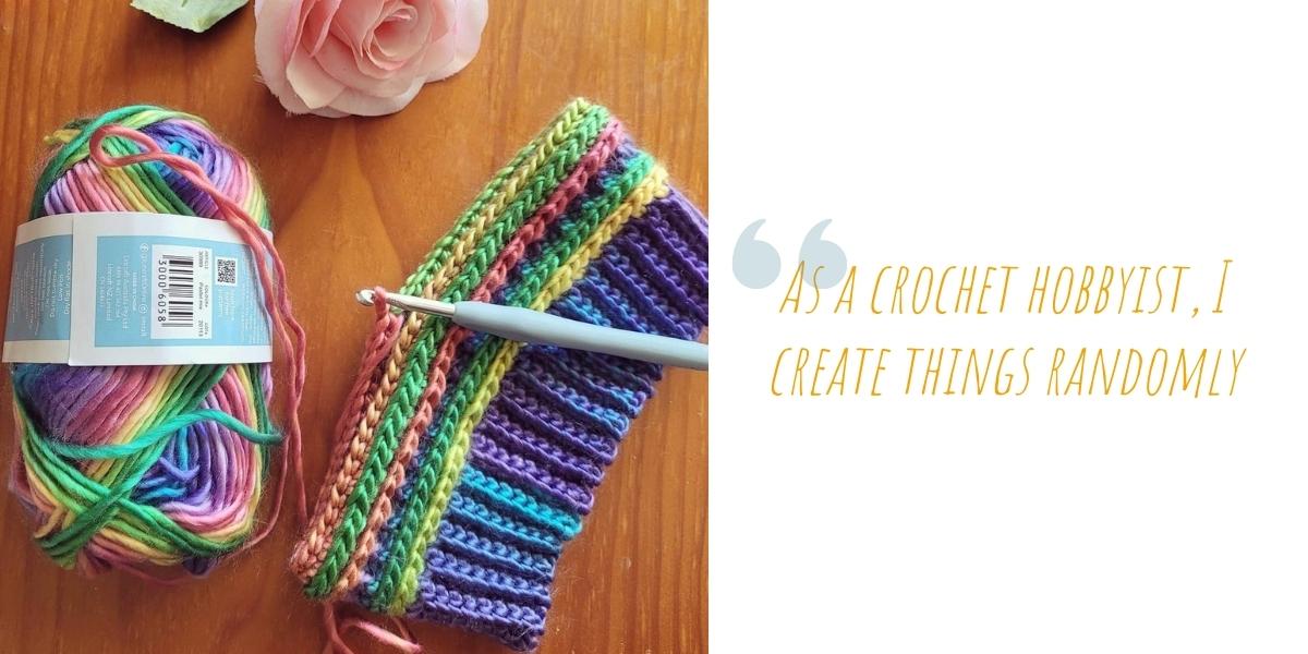A ball of rainbow yarn and a rainbow crochet beanie in progress on a wooden table; ÔAs a crochet hobbyist, I create things randomlyÕ.