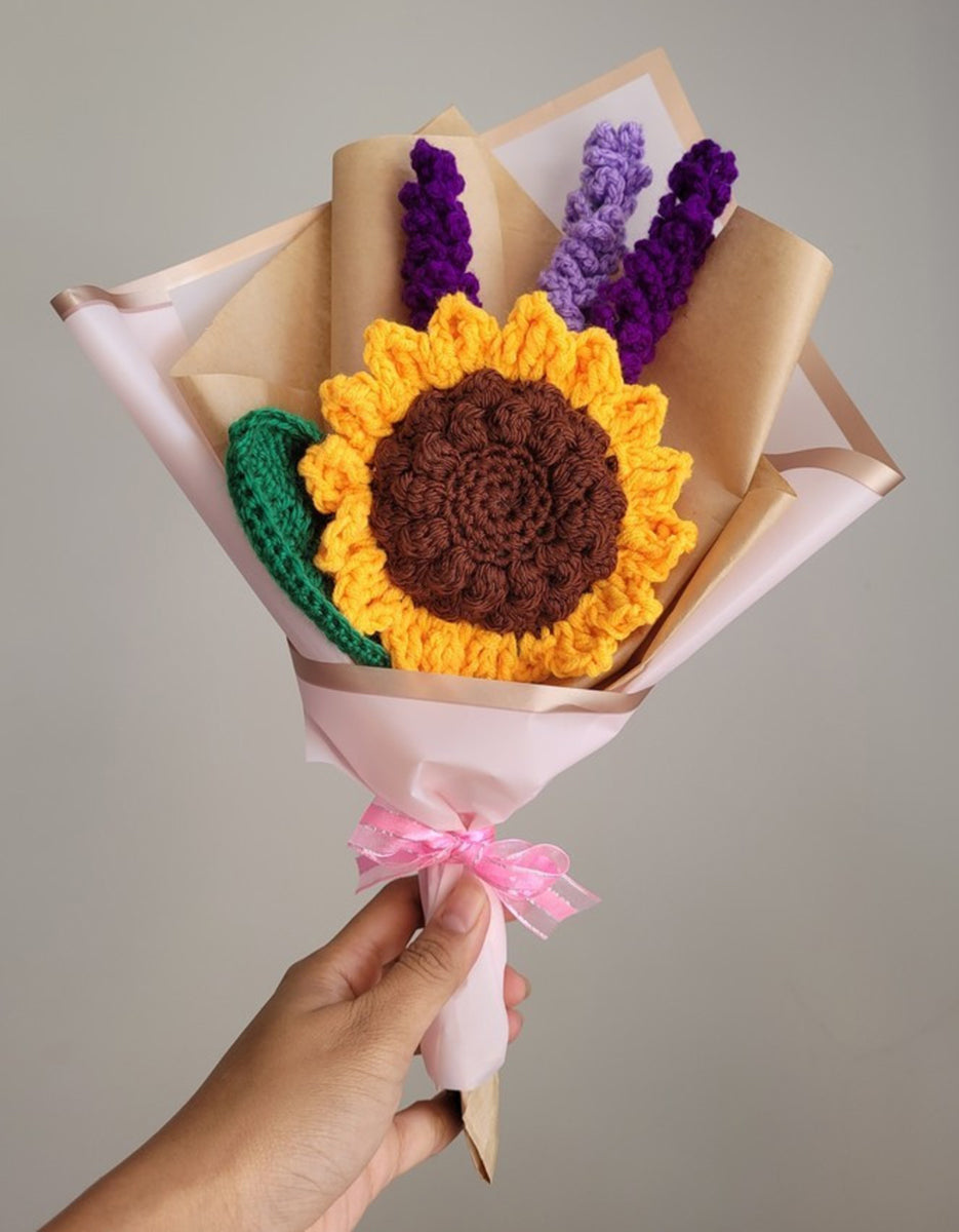 A bouquet of crochet blooms including a large golden sunflower and sprigs of crochet lavender