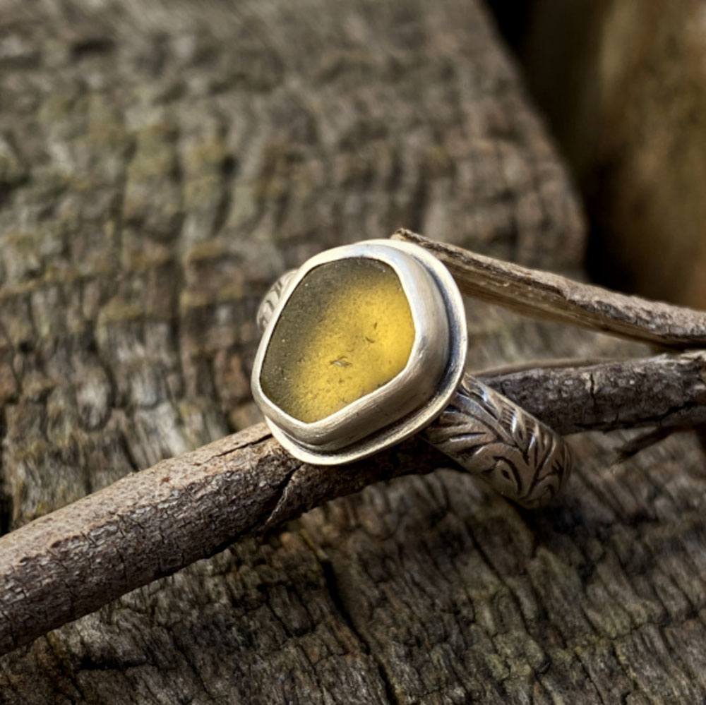 A one-of-a-kind sterling silver floral band ring set with yellow seaglass