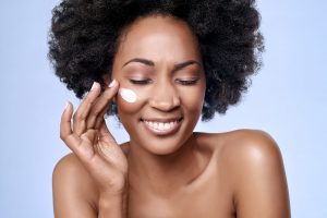 African woman using Urban Veda face cream