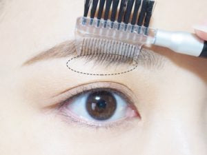 眉毛用コームを使って長い毛をカット