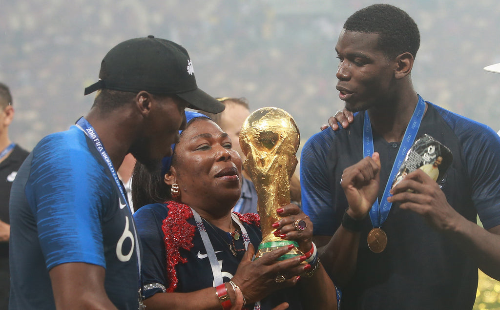 French footballer Paul Pogba and family holding the FIFA World Cup Trophy after the tournament's final match on 15 July 2018.