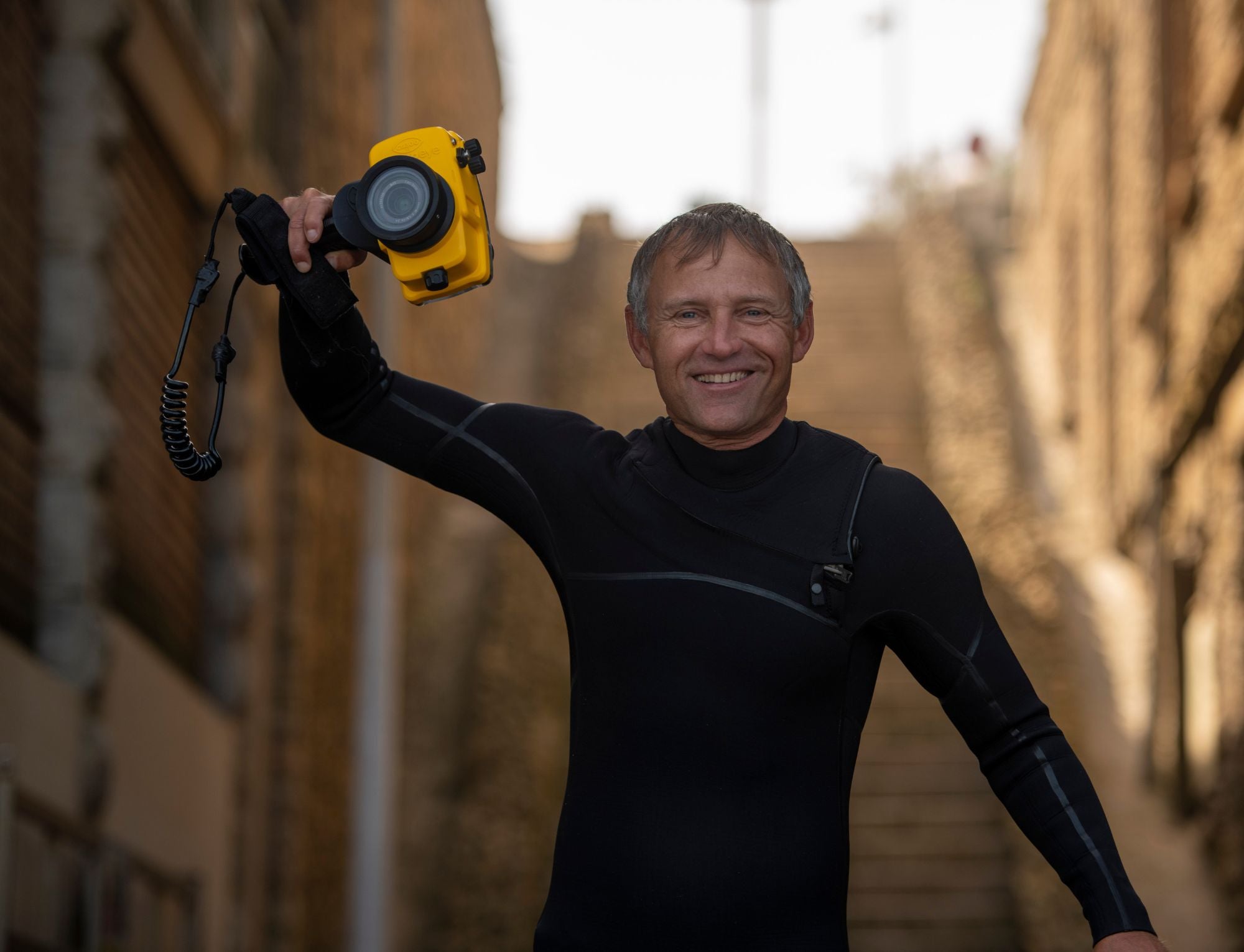 a surf photographer with a full neoprene wetsuit