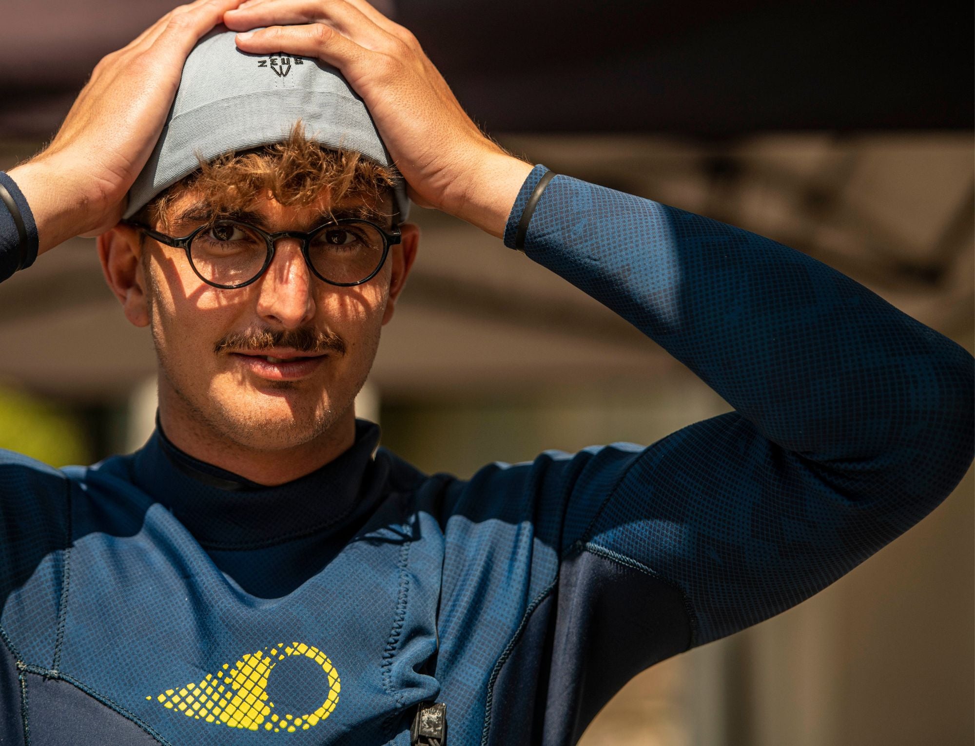 A surfer with a neoprene hat and a soouz zip free wetsuit