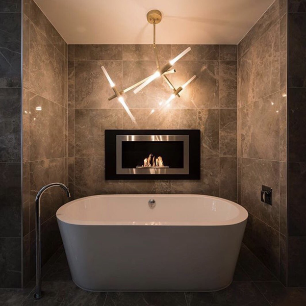 A modern fireplace burner in a bathroom.