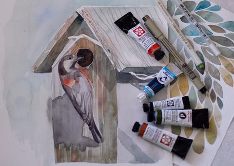 watercolor paint tubes and pens with painting of woodpecker
