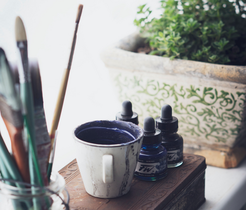 materials for ink wash: brushes, ink containers, cup of diluted ink