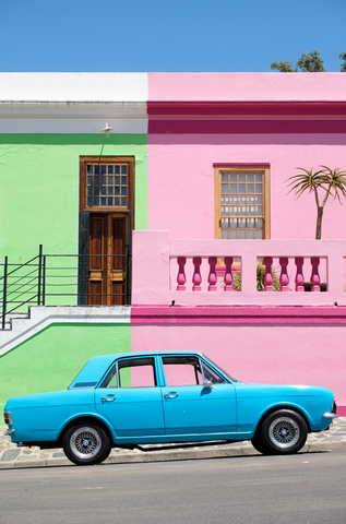 car parked in front of building, showing color theory, complementary colors