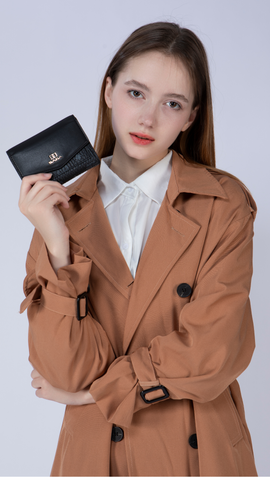 A girl holding a black luxury leather Saga wallet