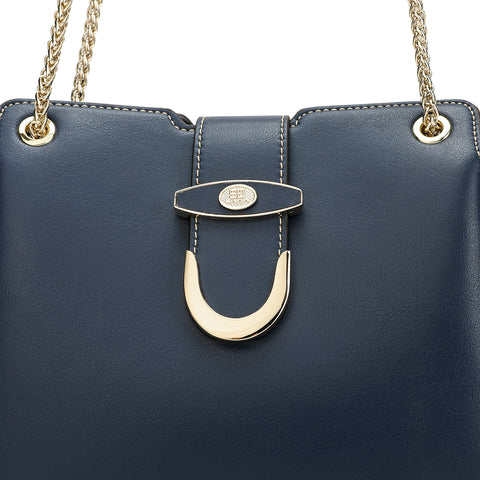 Close detailing of the navy blue bag from Saga with an elegant gold lock on the front