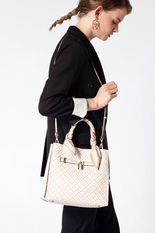 A woman wearing a beige coat and carrying a luxurious beige women's handbag with a distinctive pattern and two handles