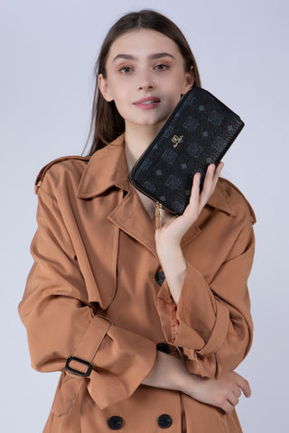 A girl holding a black Saga women's wallet with the Saga logo printed on the wallet