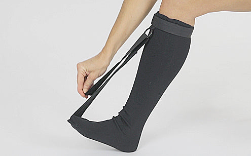 woman adjusting strap on long black stretch sock