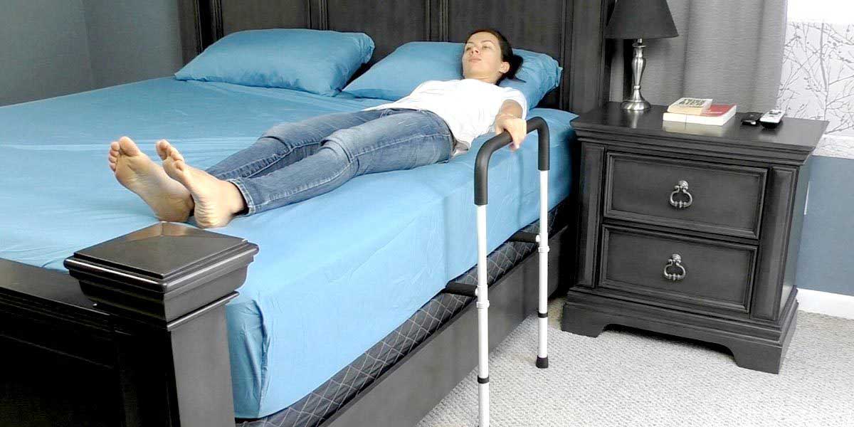 Woman in bed sleeping holding a safety rail by vive