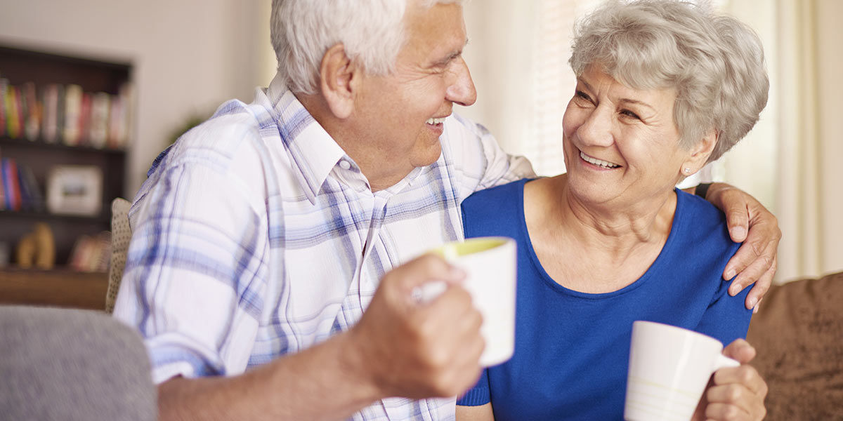 Senior couple smiling together with hot coffee