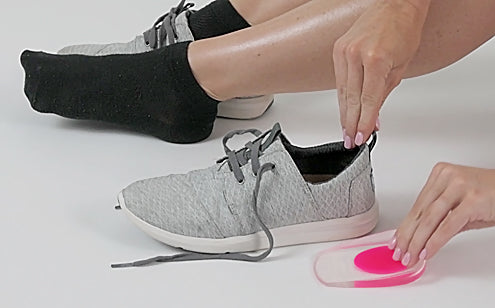 woman inserting gel heel cup into sneaker