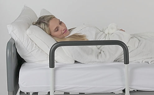 mujer descansando en la cama con barandilla