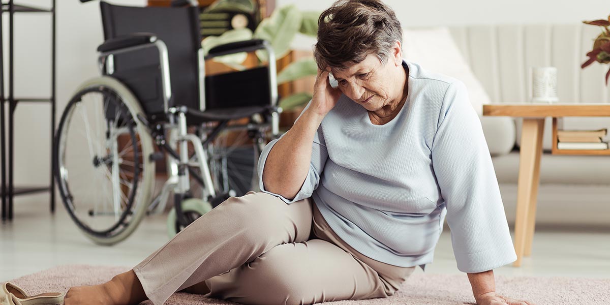 Senior woman with a headache sitting on the floor