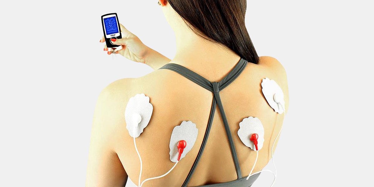 Woman using TENS unit for back pain