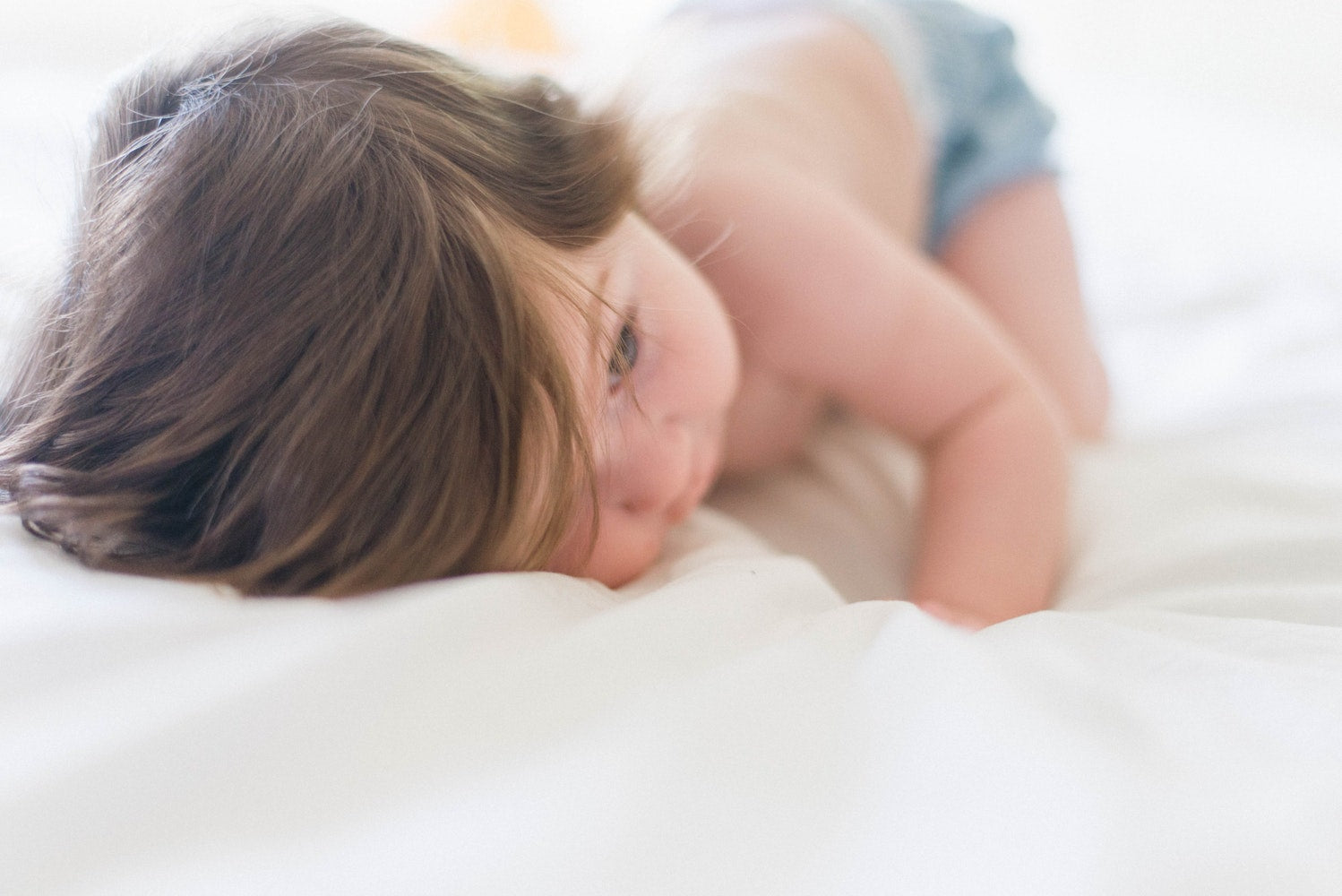 Baby napping on hotel bed