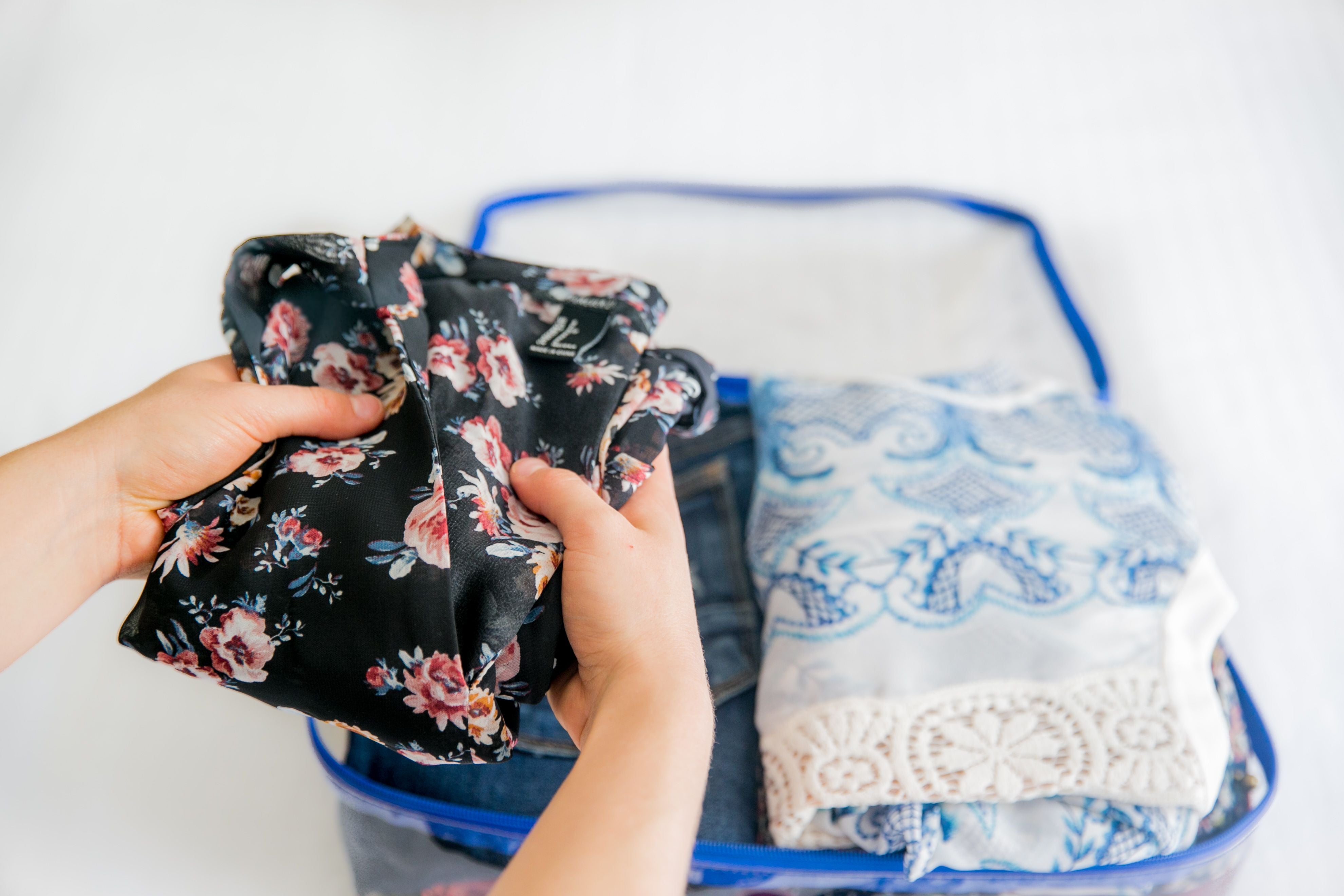 Packing women's clothes in a turquoise medium cube