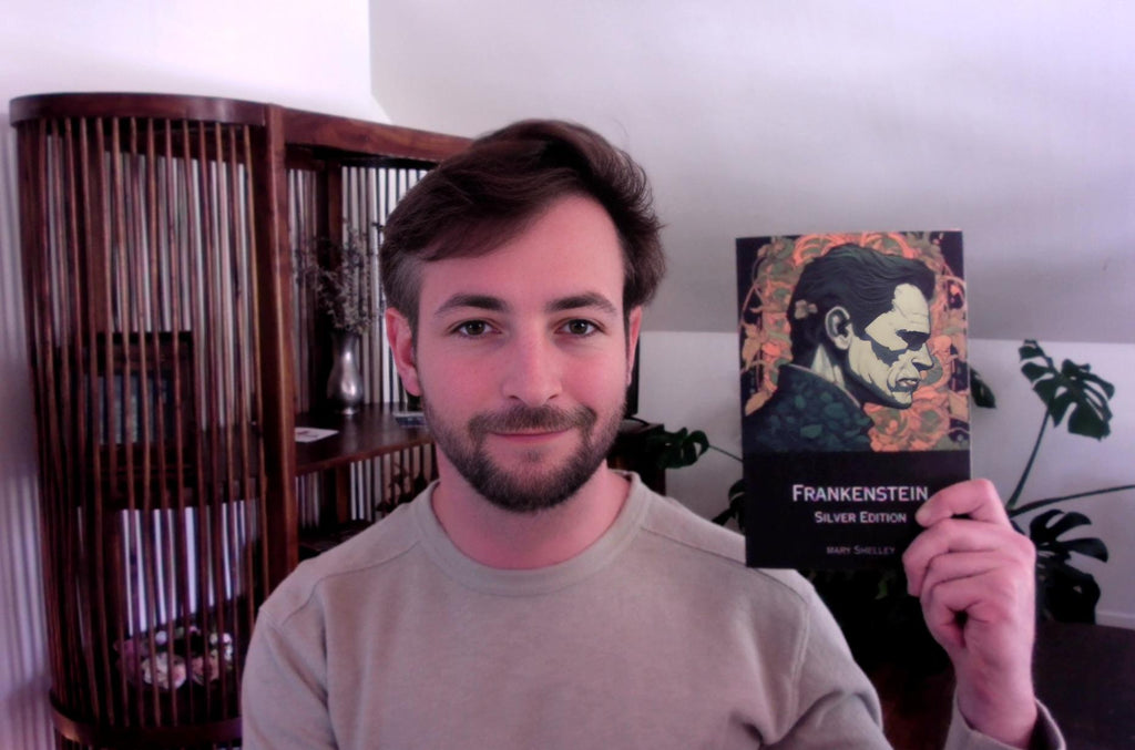 Photo of founder Ethan Pierce holding up a copy of Adaptive Reader's first novel, Frankenstein.