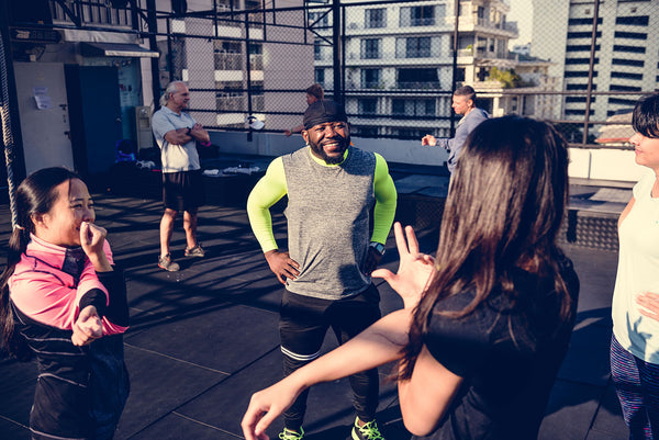 A group of people meeting and exercising at an outdoor bootcamp. 