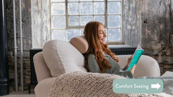 Person sitting on a cream sofa reading a book