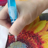 Hand gebruikt ergonomische pen voor diamond painting op een kleurrijk canvas