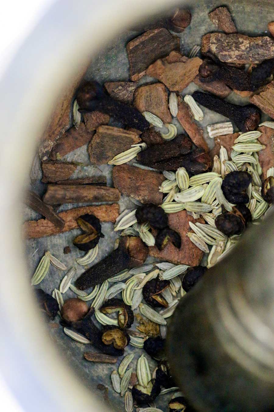 Epices sèches dans un mortier pour réaliser le mélange cinq-épices biologique