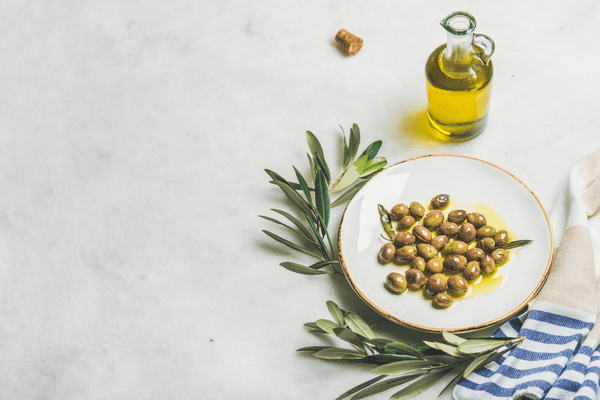 Olives on a plate, olive oil & olive branch