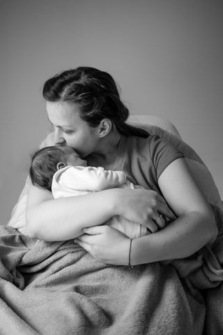 mother feeding baby breast milk