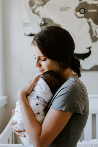 mother holding baby breast feeding