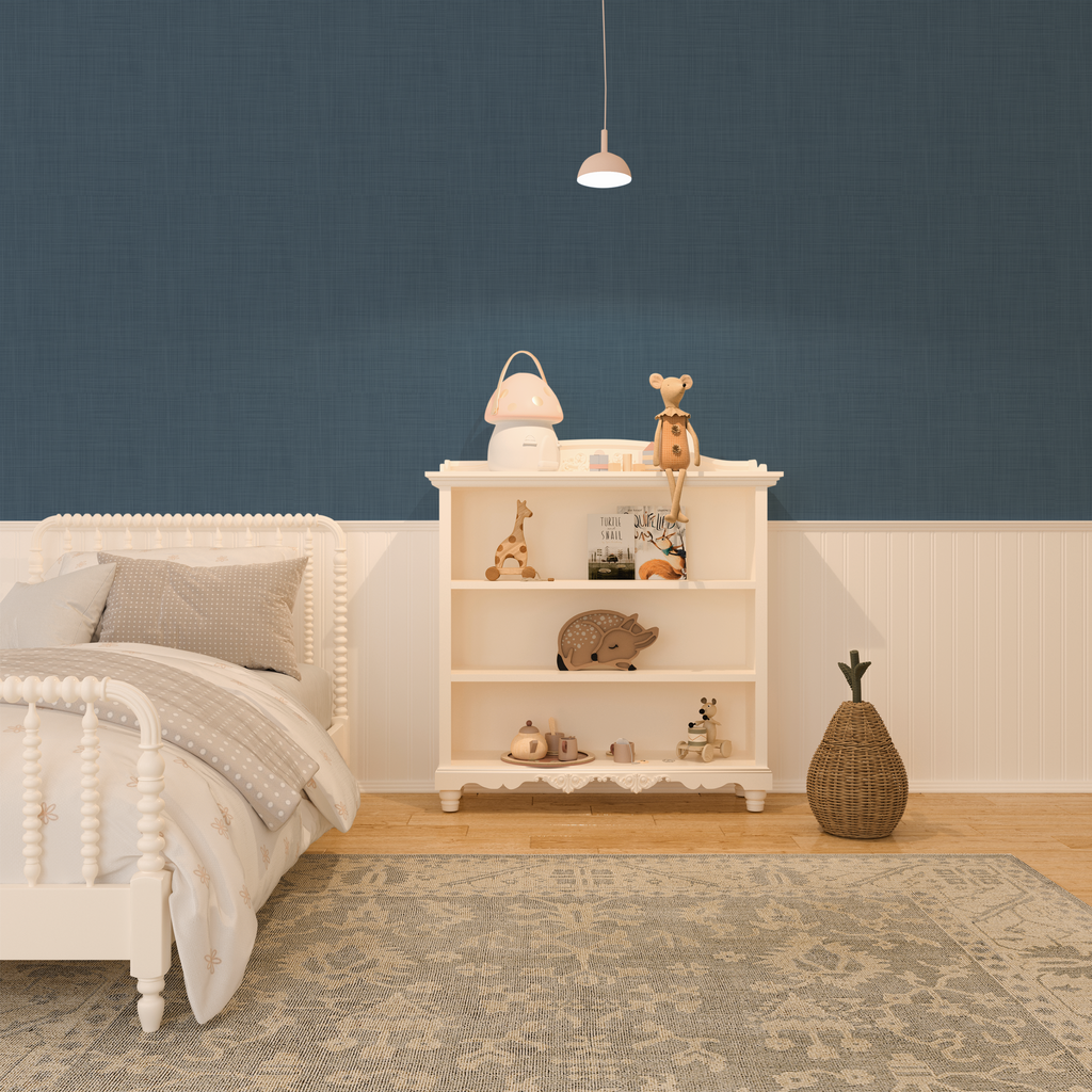 A serene bedroom setup with denim blue grasscloth peel and stick wallpaper, creating a calm backdrop for the white bed and shelving unit with children's decor.