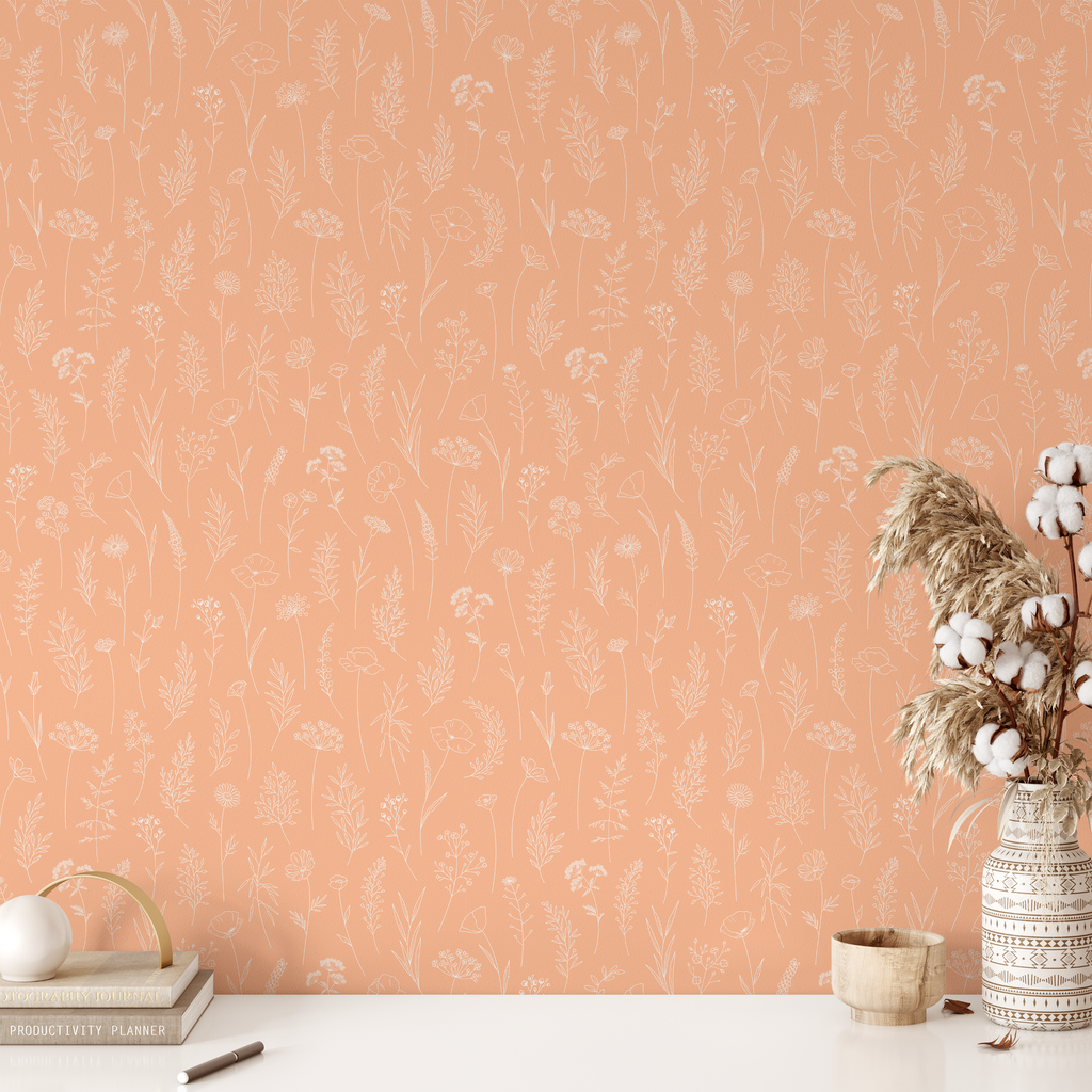 A room with botanical-themed peel and stick wallpaper in the Pantone Color of the Year, Peach Fuzz, showcasing an elegant floral design.