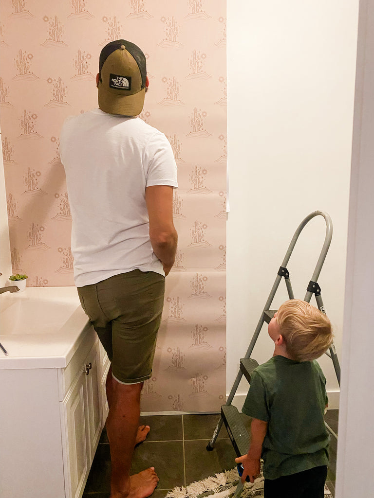 Friends installing wallpaper in a bathroom