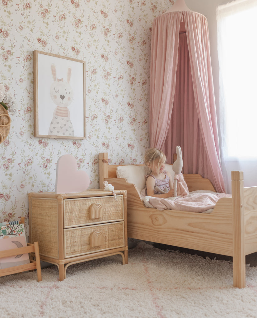 Soft pink and natural wood girls room with pink canopy and vintage floral dainty flower peel and stick wallpaper