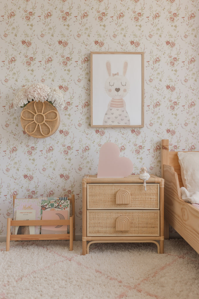 Cottage style floral peel and stick wallpaper in a little girls room with natural wood furniture