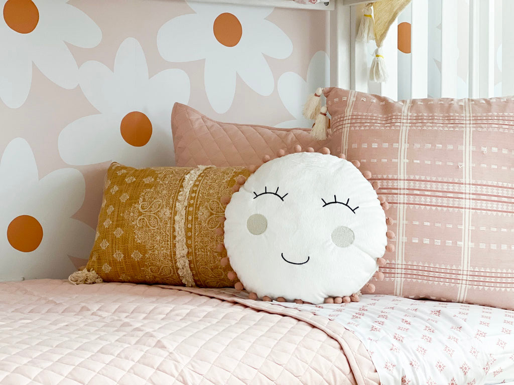 Floral daisy wall paper with smiley pillow accents