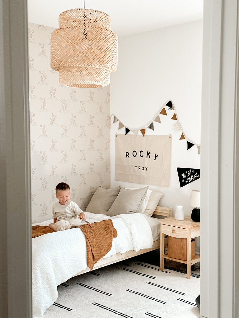 Child playing in beautiful room featuring peel and stick wallpaper and neutral decor