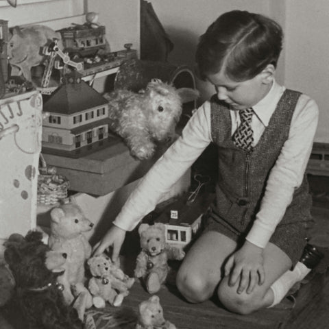 Altes schwarz-weiß Foto eines Kinds, das mit Spielzeug spielt