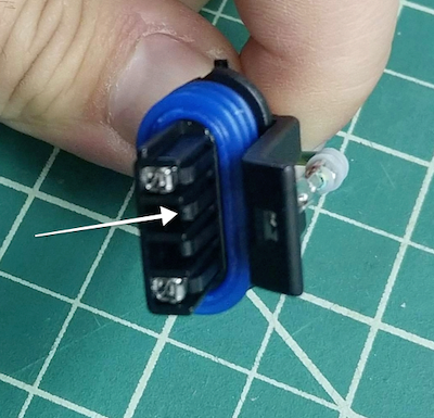 Use a small flat screwdriver or pick to pull up on the retainer clip, and pull out the middle wire.