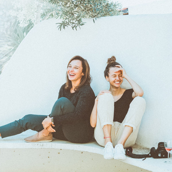 Sprinkle Club - Two women laughing on a bench after finding the best hashtags on instagram